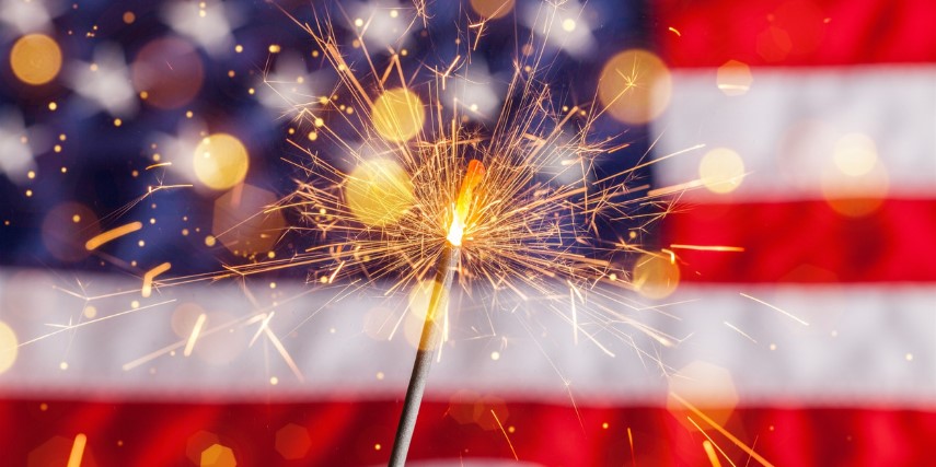 Image of a sparkler against an American flag.