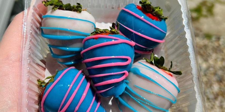 Blue candy-dipped strawberries drizzles in pink and blue chocolate.