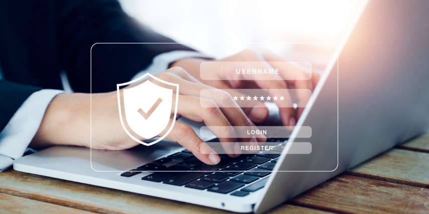 An image of a person sitting at a laptop with a security overlay on the photo.