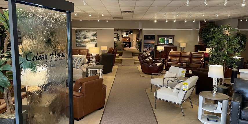 Interior photo of Colony House Furniture and Bedding, showing a long aisle and many furniture options. 