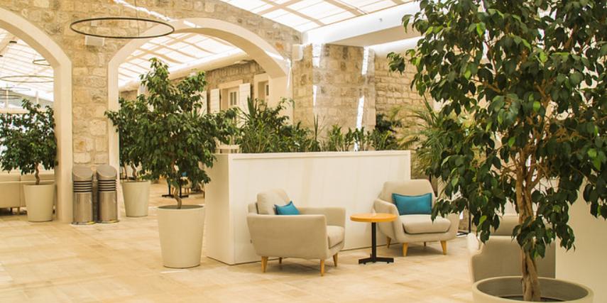 Lobby of a fancy resort with sand-colored decor, touched with hints of blue.
